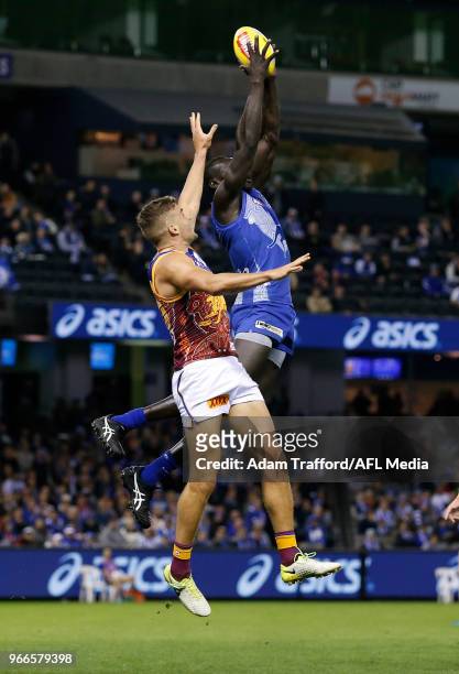Majak Daw of the Kangaroos marks the ball over Tom Cutler of the Lions during the 2018 AFL round 11 match between the North Melbourne Kangaroos and...