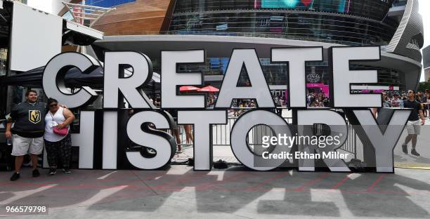 Couple poses in front of a "CREATE HISTORY" sign at a Vegas Golden Knights road game watch party for Game Three of the 2018 NHL Stanley Cup Final...