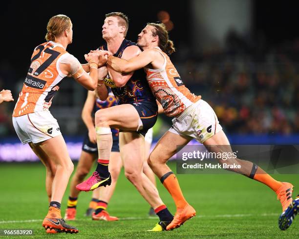 Josh Jenkins of the Adelaide Crows marks and trys to break through Harry Himmelberg and Phil Davis of the Giants and during the round 11 AFL match...