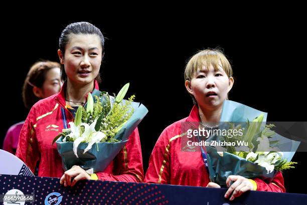 Ding Ning and Zhu Yuling of China attend the award ceremony at the women's doubles final compete with Jeon Jihee and Yang Haeun of South Korea during...