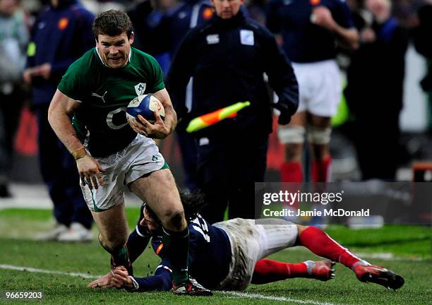 Gordon D'Arcy of Ireland slips the tackle of Clement Poitrenaud of France during the RBS Six Nations match between France and Ireland at Stade France...