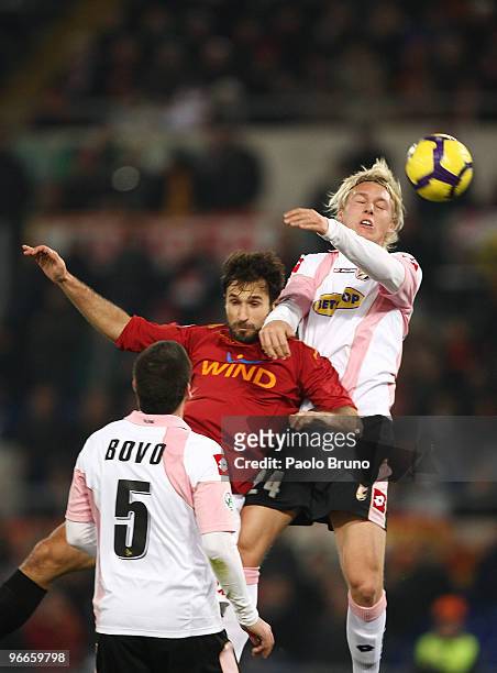 Mirko Vucinic of AS Roma and Simon Kjaer of US Citta' di Palermo in action as Cesare Bovo of US Citta' di Palermo looks on during the Serie A match...