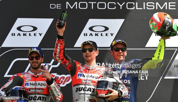 Ducati Team's Spanish rider Jorge Lorenzo poses on the podium with second placed Ducati's Team rider Italian Andrea Dovizioso and third placed...