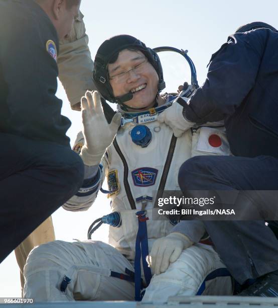 In this handout image provided by NASA, Japan Aerospace Exploration Agency astronaut Norishige Kanai is helped out of the Soyuz MS-07 spacecraft just...