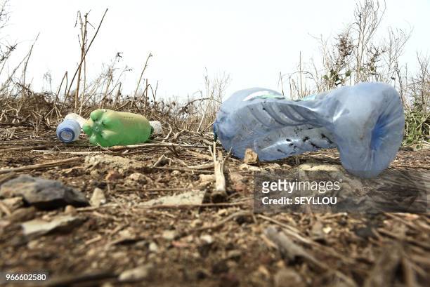 Picture taken on June 3 shows plastic bottles on the ground in the Ouakam aread of Dakar. - World Environment Day is marked annually on June 5, and...