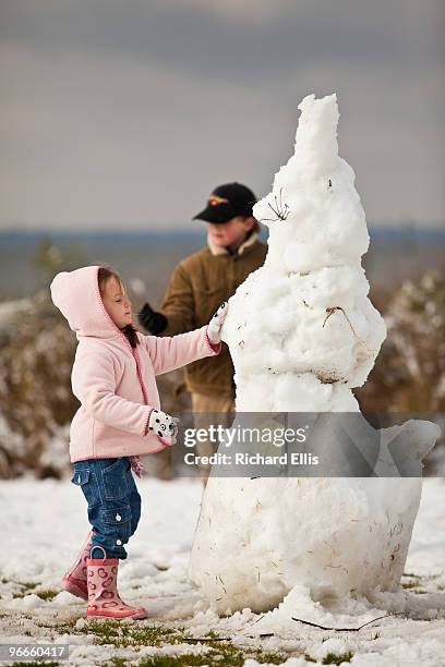 Young girl puts the finishing touches on a snowman February 13, 2010 during a rare snow storm in Mt Pleasant, South Carolina. About three inches of...