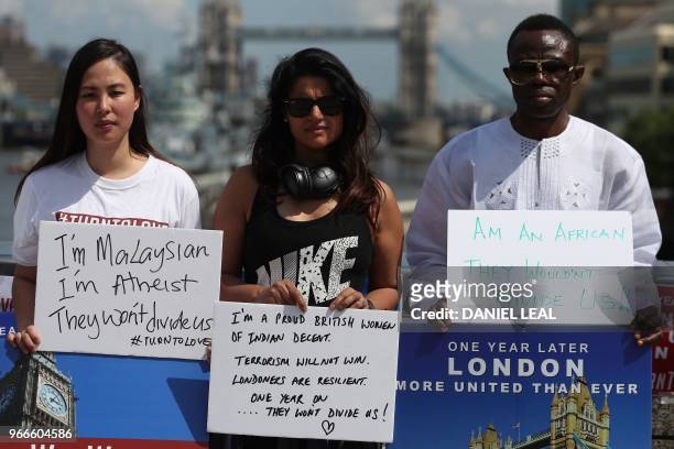 Members of various faiths hold placards as they gather on London Bridge, London on June 3 prior to a commemoration service on the first anniversary...