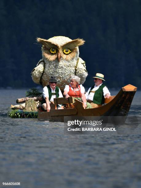 People make their way in a boat past a figure of an owl on Altauseer lake near Bad Aussee, Austria on June 3, 2018. / Austria OUT