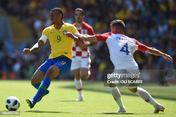 Brazil's striker Gabriel Jesus vies with Croatia's striker Ivan Perisic during the International friendly football match between Brazil and Croatia...