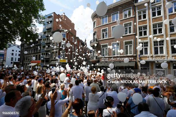 People take part in a white march to commemorate the victims of a shooting on May 29 in Liege, at the Tivoli space, in Liege city center, on June 3,...