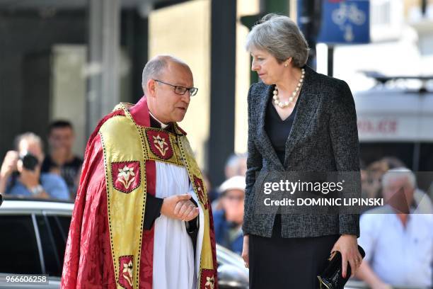 Britain's Prime Minister Theresa May is greeted by the Dean of Southwark, Andrew Nunn on her arrival for a Service of Commemoration on the first...