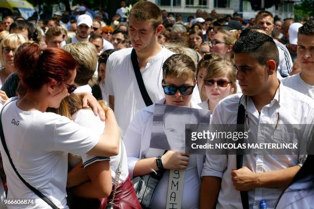 People take part in a white march to commemorate the victims of a shooting on May 29 in Liege, at the Tivoli space, in Liege city center, on June 3,...