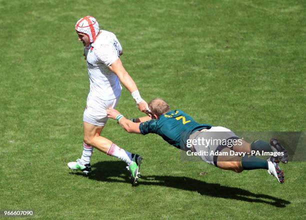 England's Phil Burgess beats South Africa's Philip Snyman to score a try during day two of the HSBC London Sevens at Twickenham Stadium, London.