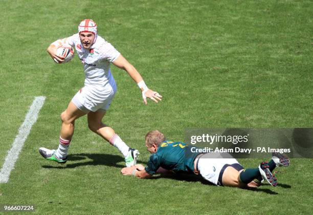 England's Phil Burgess beats South Africa's Philip Snyman to score a try during day two of the HSBC London Sevens at Twickenham Stadium, London.