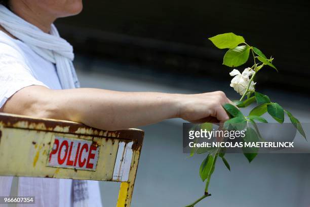 Picture taken and released on June 3, 2018 shows a person holding a white carnation during a white march to commemorate the victims of a shooting on...