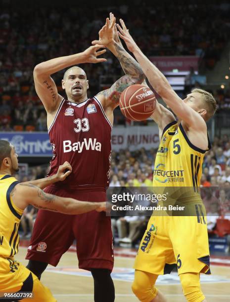 Maik Zirbes of FC Bayern Muenchen competes with Peyton Siva and Niels Giffey of ALBA Berlin during the first play-off game of the German Basketball...
