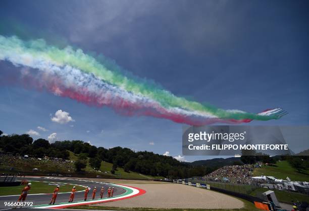 The Italian Air Force aerobatic unit Frecce Tricolori spread smoke with the colors of the Italian flag prior the Moto GP Grand Prix at the Mugello...