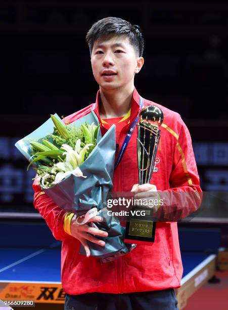 Ma Long of China poses with trophy during awarding ceremony after winning men's singles final match against Fan Zhendong of China on day four of the...