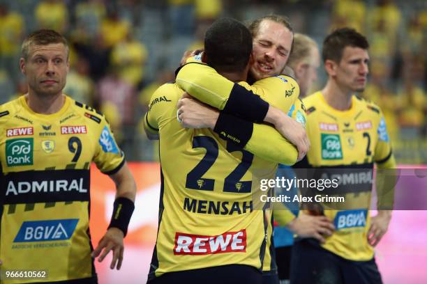 Kim Ekdahl du Rietz of Rhein-Neckar Loewen hugs team mate Mads Mensah Larsen after the DKB HBL match between Rhein-Neckar Loewen and DHfK Leipzig at...