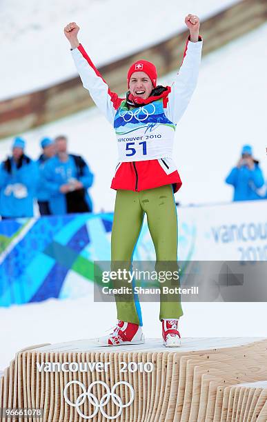 Simon Ammann of Switzerland celebrates on the podium after winning the gold medal in the Ski Jumping Normal Hill Individual on day 2 of the Vancouver...