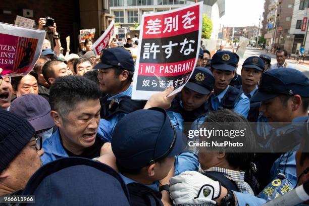 Protesters holding up signs, including one saying &quot;NO HATE &amp; NO RACISM&quot; gather in front of Educational Cultural Hall in Kawasaki,...