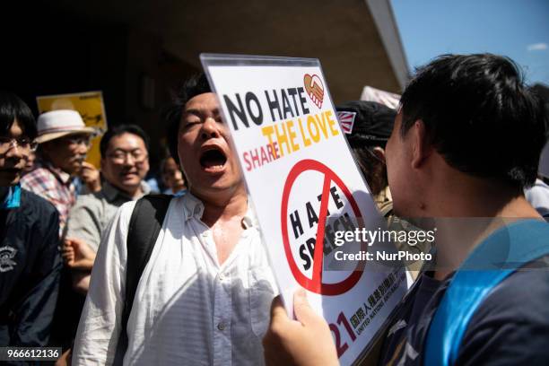 Protesters holding up signs, including one saying &quot;NO HATE &amp; NO RACISM&quot; gather in front of Educational Cultural Hall in Kawasaki,...