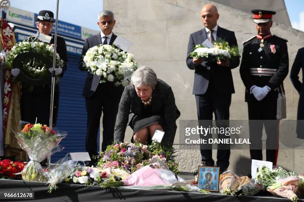 Britain's Prime Minister Theresa May lays a floral tribute at Southwark Needle on London Bridge, London on June 3 during a commemoration service on...