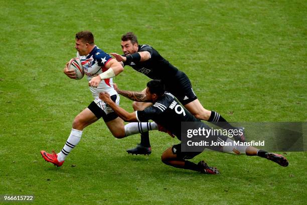 Stephen Tomasin of the USA is tackled by Regan Ware and Kurt Baker of New Zealand on day two of the HSBC London Sevens at Twickenham Stadium on June...