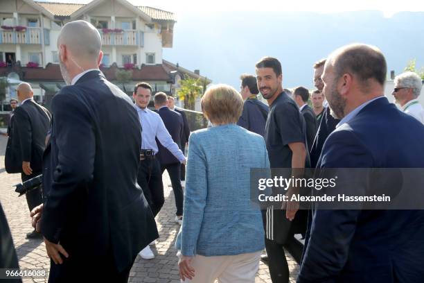 German Chancellor Angela Merkel arrives with player Sami Khedira at the team hotel Hotel Weinegg of the German national team a during her visit at...