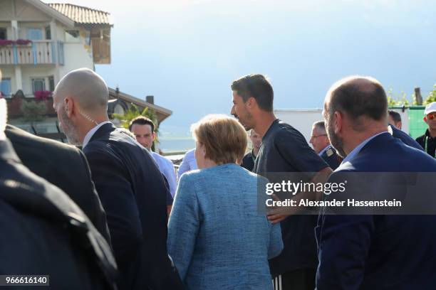 German Chancellor Angela Merkel arrives with player Sami Khedira at the team hotel Hotel Weinegg of the German national team a during her visit at...