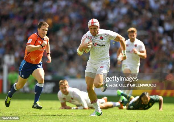 England's Phil Burgess runs in a try during the cup semi-final rugby union 7s game between England and South Africa on the second day of the 2018...