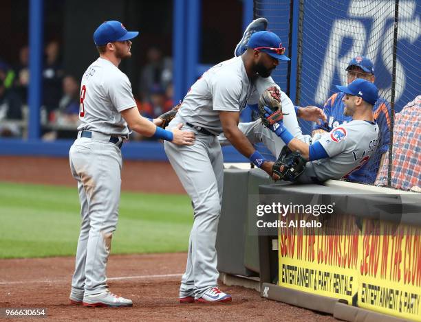 Tommy La Stella of the Chicago Cubs avoids a crash with Ian Happ and Jason Heyward who caught a foul ball against the New York Mets during their game...