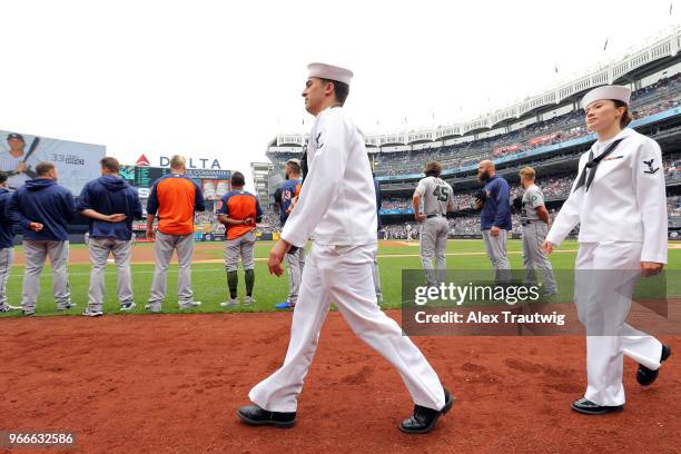 Members of the Navy leave the field following the national anthem ahead of a game between the New York Yankees and the Houston Astros at Yankee...