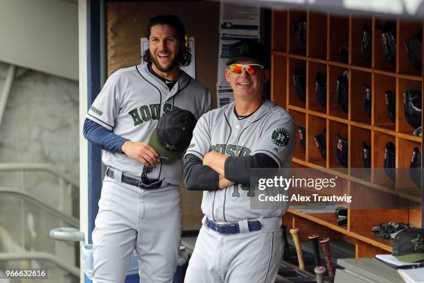 Jake Marisnick and Manager AJ Hinch of the Houston Astros stand in the dugout ahead of a game against the New York Yankees at Yankee Stadium on...