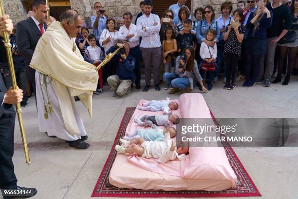 Priest blesses babies during 'El Colacho', the 'baby jumping festival' in the village of Castrillo de Murcia, near Burgos on June 3, 2018 - Baby...