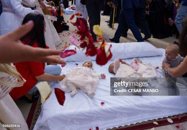 People throw rose petals over babies on a mattress in the street during 'El salto del Colacho', the baby jumping festival in the village of Castrillo...