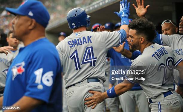 Justin Smoak of the Toronto Blue Jays celebrates in the dugout after hitting a two run home run during the sixth inning of the game against the...