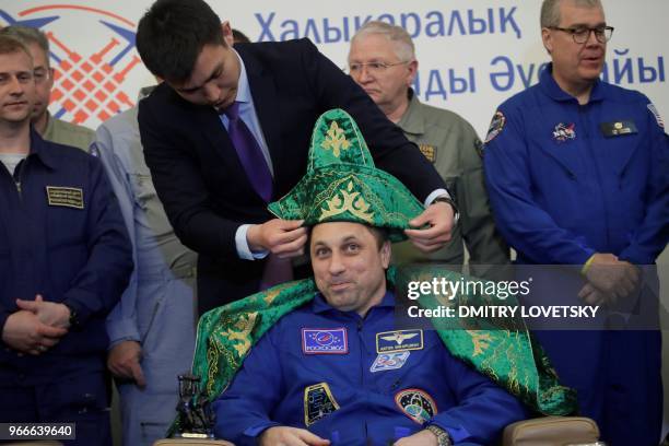 Karaganda city official puts a Kazakh national hat on Russian cosmonaut Anton Shkaplerov , after the landing of the Russian Soyuz MS-07 space capsule...