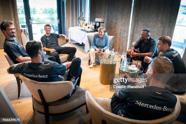 In this handout photo provided by the German Government Press Office , German Chancellor Angela Merkel talks to Sami Khedira, Thomas Müller, Jerome...