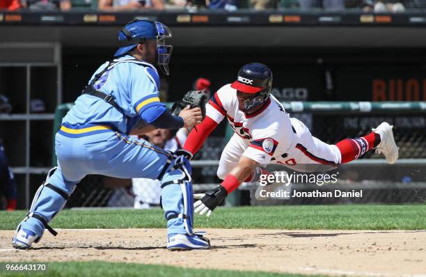 Yoan Moncada of the Chicago White Sox dives in to score a run as Manny Pina of the Milwaukee Brewers awaits the throw in the 5th inning at Guaranteed...