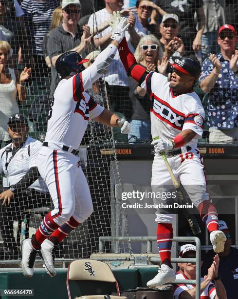 Yoan Moncada of the Chicago White Sox leaps to high-five teammate Daniel Palka after Palka hit a two run home run in the 6th inning against the...