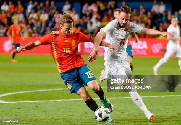 Spain's midfielder Nacho Monreal vies with Switzerland's forward Josip Drmic during the international friendly football match between Spain and...