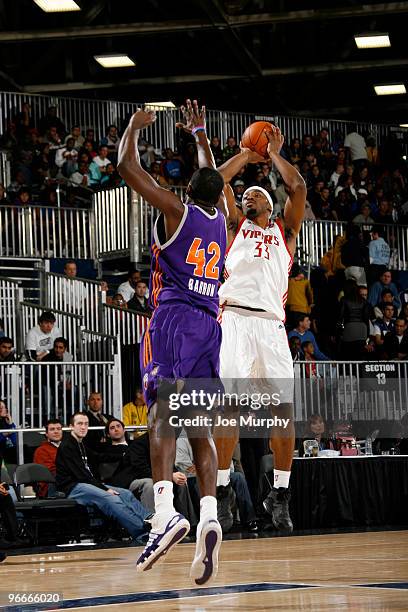Mike Harris of the West All-Star Team shoots the ball over Earl Barron of the East All-Star Team during the NBA D-League All-Star Game on center...
