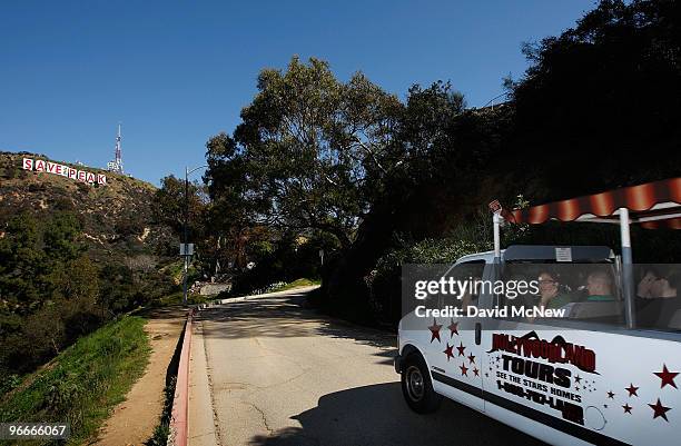 Hollywood tour bus passes near the iconic 450-foot-long Hollywood sign after activists covered it with banners during an effort to prevent the...