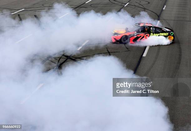 Martin Truex Jr., driver of the Bass Pro Shops/5-hour ENERGY Toyota, celebrates with a burnout after winning the Monster Energy NASCAR Cup Series...