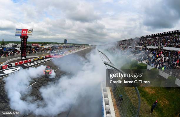 Martin Truex Jr., driver of the Bass Pro Shops/5-hour ENERGY Toyota, celebrates with a burnout after winning the Monster Energy NASCAR Cup Series...