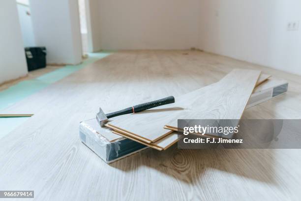 hammer on sheets of wood laminate floor - laminat stock-fotos und bilder