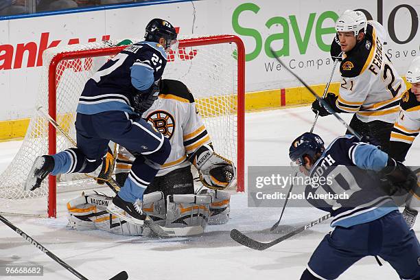 Steven Reinprecht of the Florida Panthers jumps in the air in front of goaltender Tuukka Rask of the Boston Bruins in an attempt to block his view on...