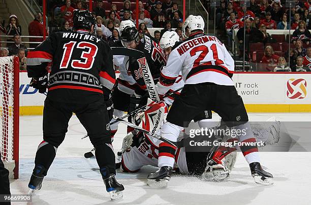 Goaltender Martin Brodeur of the New Jersey Devils and teammate Rob Niedermayer defend the net against Jussi Jokinen and Ray Whitney of the Carolina...