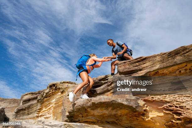 man giving a hand to a woman while hiking - hiking australia stock pictures, royalty-free photos & images